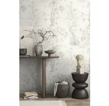 Dekoratívna izba s kvetinovou tapetou, dreveným stolom, umeleckými dielami a dekoratívnymi predmetmi.