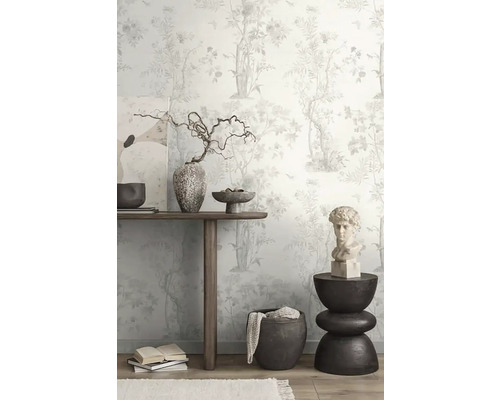 Dekoratívna izba s kvetinovou tapetou, dreveným stolom, umeleckými dielami a dekoratívnymi predmetmi.