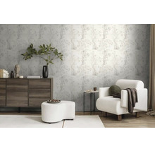 Obývacia izba so vzorovanou tapetou, komodou, kreslom a podnožkou pre svetlú a organizovanú atmosféru.