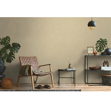 Obývacia izba s prúteným kreslom, príručným stolíkom a dekoráciami na poličke