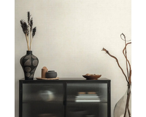 Dekoratívny interiér s čiernou skrinkou, vázami a sušenými kvetmi na béžovej tapete.