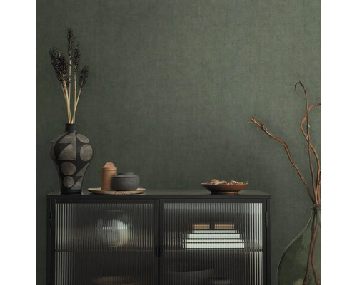 Dekoratívny príborník s vázami a miskami pred štruktúrovanou stenou