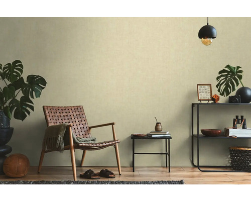 Obývacia izba s ratanovým kreslom, príručným stolíkom a regálom s dekoráciami pre útulnú atmosféru.