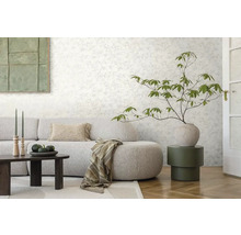 Obývacia izba s kvetinovou tapetou, pohovkou, stolom a dekoráciami pre útulnú atmosféru.