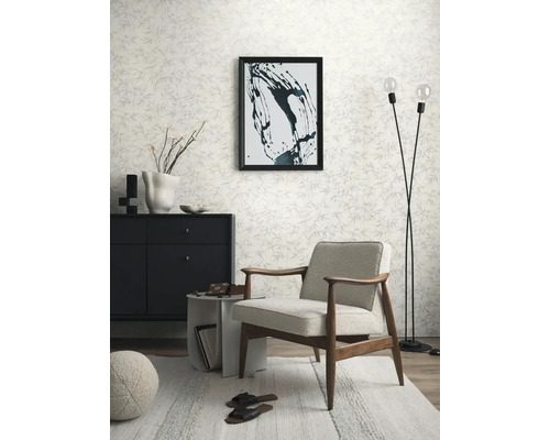 Obývacia izba s kreslom, komodou, stojacou lampou a vzorovanou tapetou pre svetlú a usporiadanú atmosféru