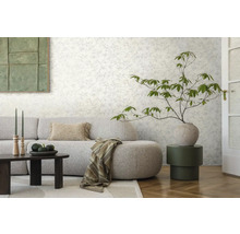 Obývacia izba so vzorovanou tapetou, pohovkou, stolom a dekoráciami pre štýlové prostredie.