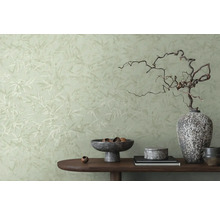 Dekoratívna izba so vzorovanou tapetou a stolom s rôznymi dekoratívnymi prvkami.