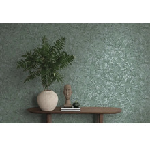 Dekoratívne bytové prostredie so vzorovanou tapetou, stolom a rastlinou v kvetináči