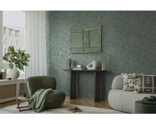 Obývacia izba so zelenou tapetou s motívom listov, kreslom a pohovkou