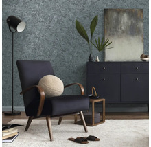 Obývacia izba s kreslom, komodou, stojacou lampou a vzorovanou tapetou