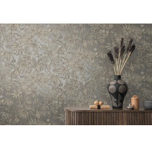 Dekoratívna stena s tropickým rastlinným vzorom nad drevenou skriňkou s vázami a dekoratívnymi predmetmi.