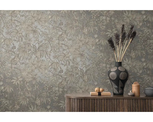 Dekoratívna stena s tropickým rastlinným vzorom nad drevenou skriňkou s vázami a dekoratívnymi predmetmi.