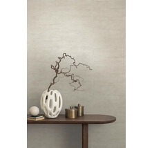 Dekoratívna váza s vetvou na drevenom stole pred štruktúrovanou stenou