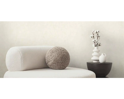 Scéna s kreslom, vankúšom a dekoráciou na odkladacom stolíku