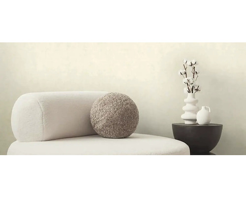 Dekoratívna scéna s kreslom, okrúhlym vankúšom, vázou s bavlnenými vetvami a stolom