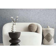 Dekoratívne usporiadanie obývacej izby s pohovkou, príručným stolíkom, vankúšom a košíkom