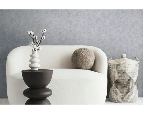 Dekoratívne usporiadanie obývacej izby s pohovkou, príručným stolíkom, vankúšom a košíkom