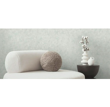 Svetlý interiér so stoličkou, ozdobným vankúšom, vázami a bavlnenými vetvami pre štýlové bývanie