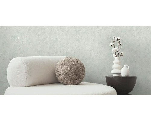 Svetlý interiér so stoličkou, ozdobným vankúšom, vázami a bavlnenými vetvami pre štýlové bývanie