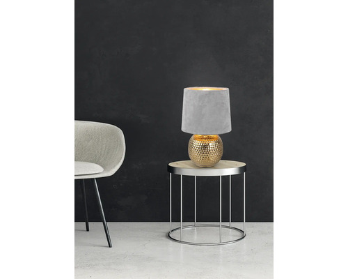 Dekoratívna stolová lampa s okrúhlym textilným tienidlom na odkladacom stolíku