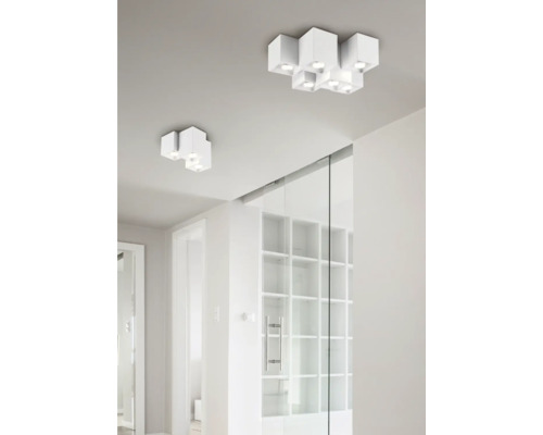 Dve biele stropné svietidlá s niekoľkými reflektormi v jasnej miestnosti