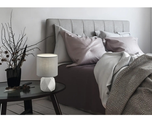 Spálňa s posteľou, nočným stolíkom a stolnou lampou