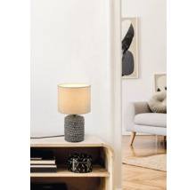 Dekoratívna stolná lampa na nočnom stolíku v obývacej izbe.