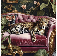 Leopard leží na červenej pohovke pred kvetinovou výzdobou.