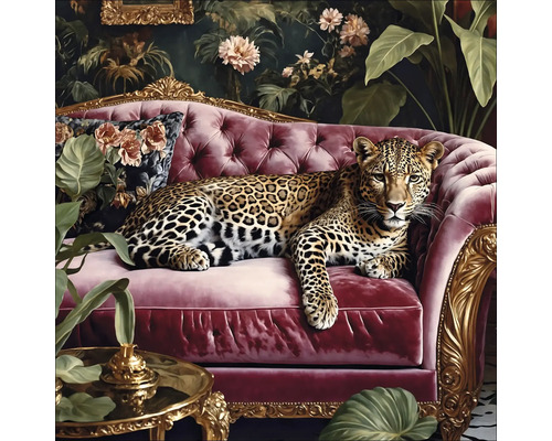 Sklenený obraz Big Cat On The Couch I 50x50 cm Leopard leží na červenej pohovke pred kvetinovou výzdobou.