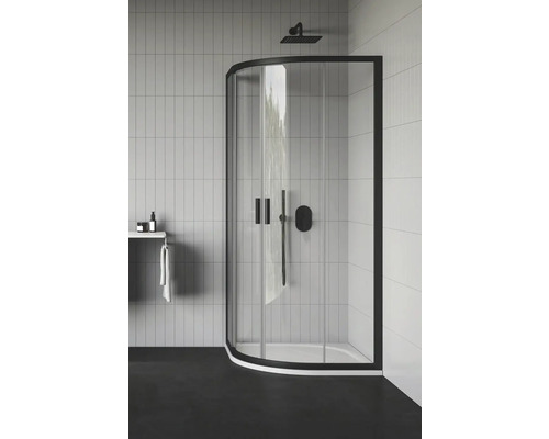 Moderná kúpeľňa so sprchovacím kútom s čiernym rámom a armatúrami, obdĺžnikové biele obklady na stenách, polica s uterákom a kozmetickými produktmi