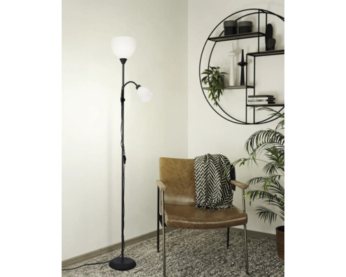 Stojacia lampa s dvomi svetlami vedľa kresla a nástennej police
