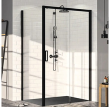 Sprchovací kút s čiernym rámom a sprchovacím systémom pred bielou obkladanou stenou