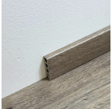 Drevená podlahová lišta pripevnená k stene