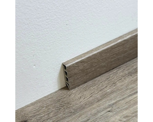 Drevená podlahová lišta pripevnená k stene