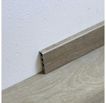 Plastová podlahová lišta s dreveným dekorom na stene a podlahe