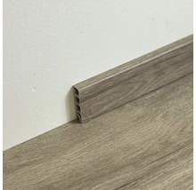 Plastová podlahová lišta s dreveným vzhľadom pri stene