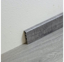 Sivá plastová podlahová lišta na podlahe a na stene