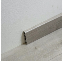 Plastová podlahová lišta s drevenou štruktúrou na stene a podlahe