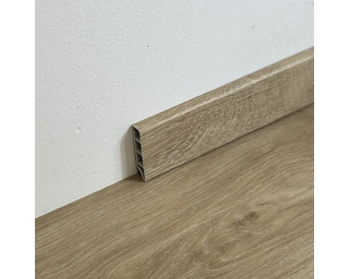 Plastová soklová lišta s drevenou štruktúrou na podlahe a stene