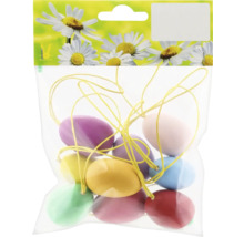 Balenie rôznofarebných veľkonočných vajíčok na žltej nite