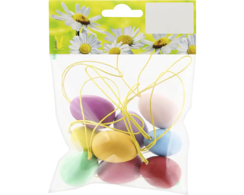 Balenie rôznofarebných veľkonočných vajíčok na žltej nite