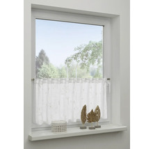 Okno s bielou záclonou a dekoráciou na parapete