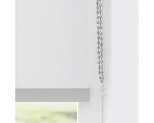 Detail bielej rolety s retiazkovým ovládaním na dekoráciu okien