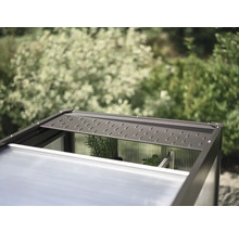 Detailný pohľad na skleník s otvoreným strešným oknom na vetranie.