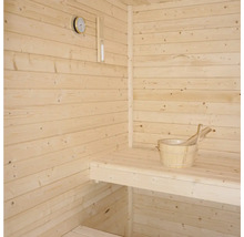 Sauna s drevenými stenami, sedadlom, teplomerom a dreveným vedrom s naberačkou