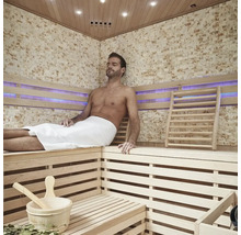 Sauna s dreveným obkladom a relaxujúcim mužom