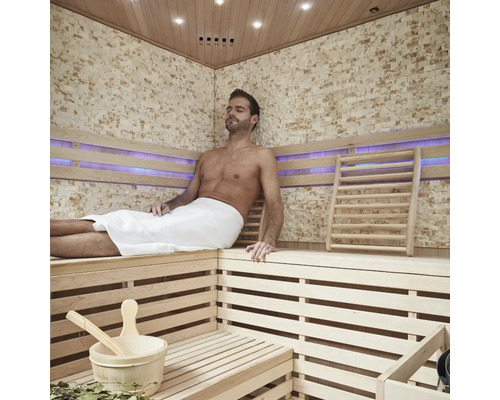 Sauna s dreveným obkladom a relaxujúcim mužom