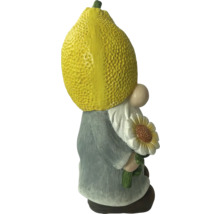 Záhradný trpaslík s citrónom ako hlavou a slnečnicou v ruke