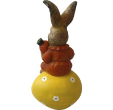 Dekoratívny zajac na veľkonočnom vajci s mrkvou v ruke ako záhradná dekorácia