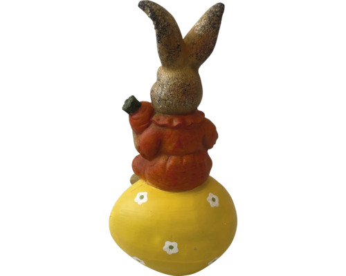 Dekoratívny zajac na veľkonočnom vajci s mrkvou v ruke ako záhradná dekorácia